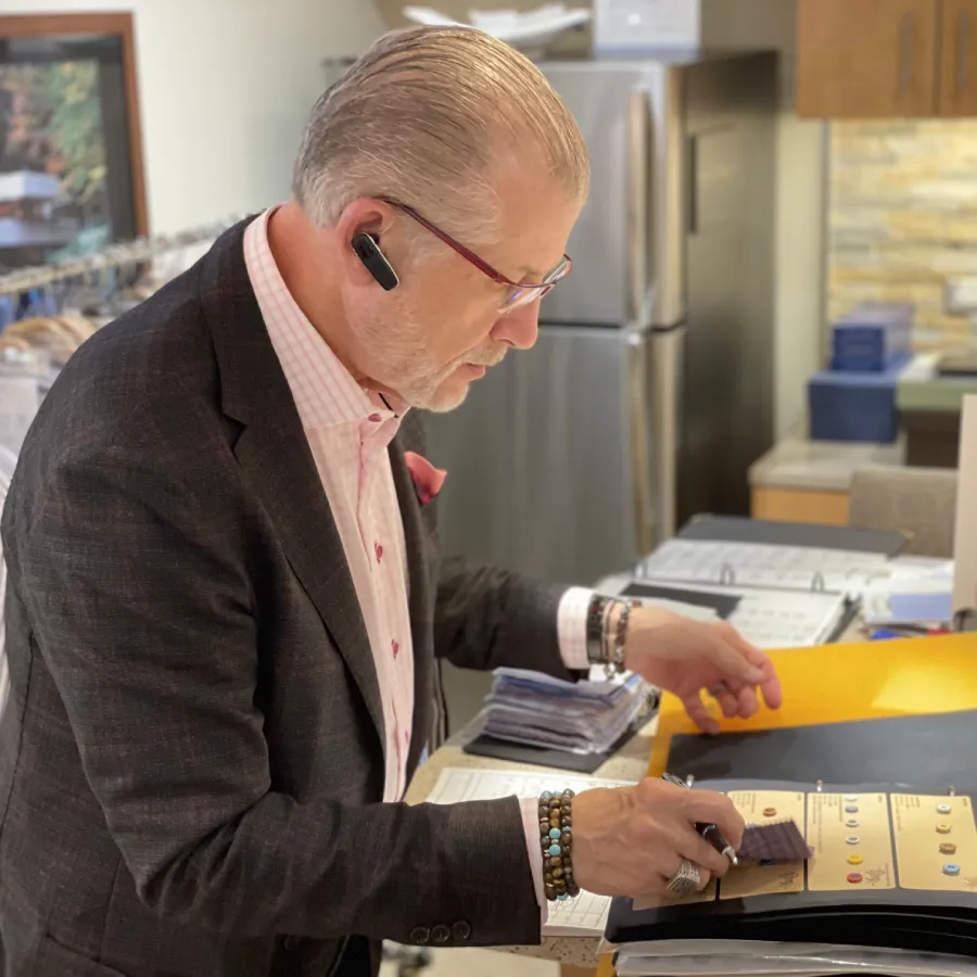 Davelle clothier selecting materials for a custom clothing consultation