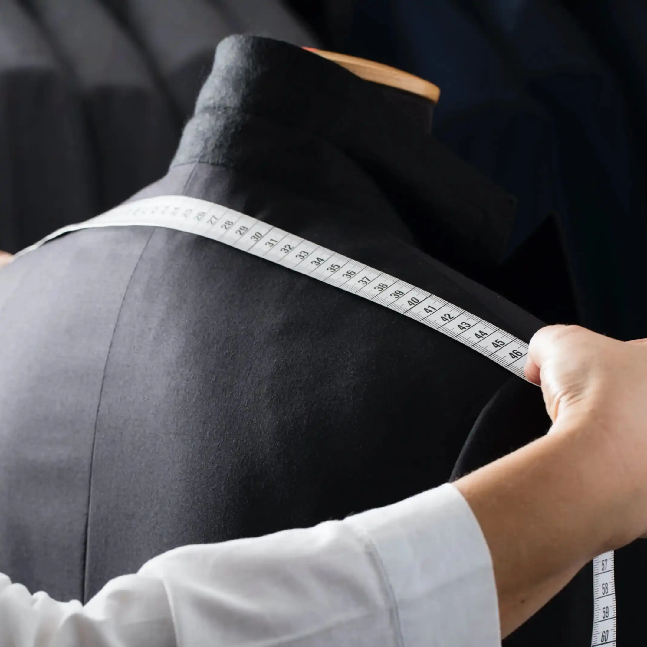 Tailor measuring a men's jacket for alterations