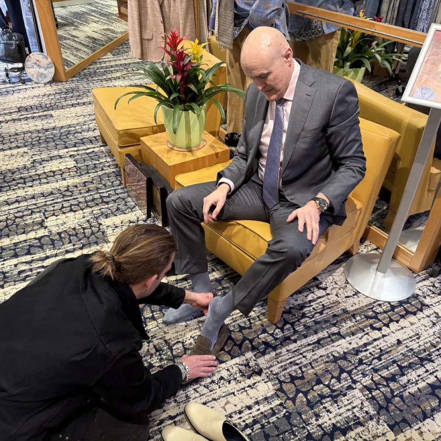 Customer being fitted for men's shoes at Davelle Clothiers